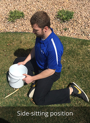 A man demonstrates the side-sitting position outside on a green lawn. 